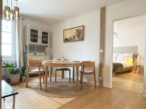 - une salle à manger avec une table, des chaises et un lit dans l'établissement L'Alcove, à Chartres
