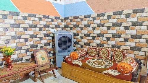 een kamer met een bed en een bakstenen muur bij Sahara Family Homestay in Mysore