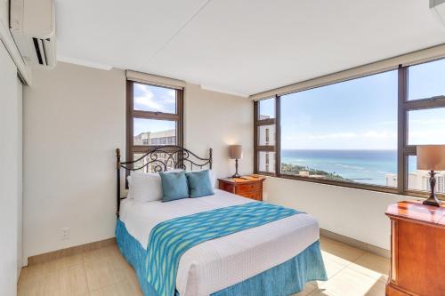 een slaapkamer met een bed en een groot raam bij 37th Floor Condo with Sweeping Ocean Views & Free parking! condo in Honolulu