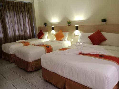 um quarto de hotel com três camas num quarto em bintang hotel em Kuala Lumpur