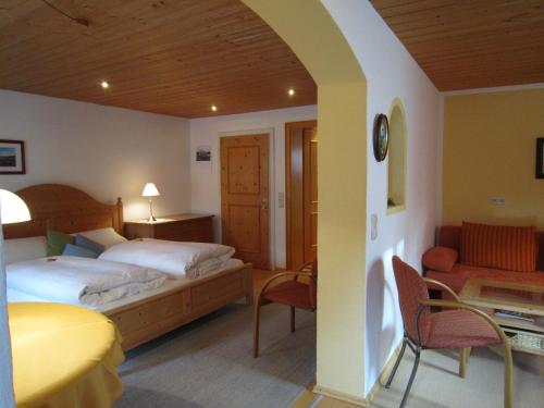 a hotel room with a bed and a couch at Gästehaus Unruh in Oberammergau