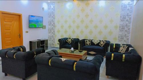 a living room with blue couches and a tv at BED AND BREAKFAST ISLAMABAD - cottages in Islamabad