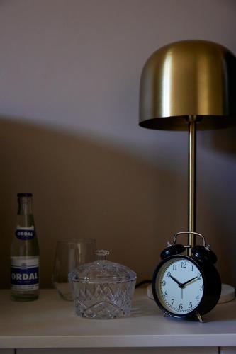 a clock sitting on a table next to a lamp at Le Sommelier in Bailleul