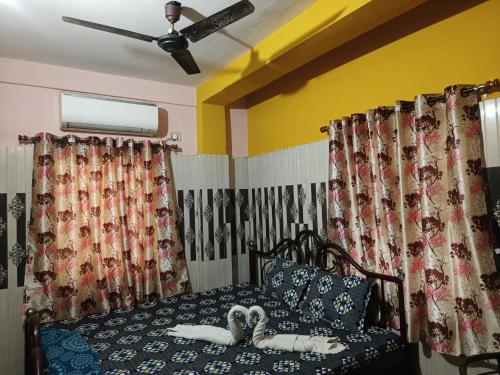 a bedroom with a bed with a ceiling fan at SWASTI DEEP GUEST HOUSE in Kolkata