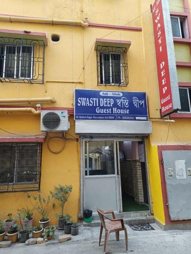 a sign for a guest house on the side of a building at SWASTI DEEP GUEST HOUSE in Kolkata