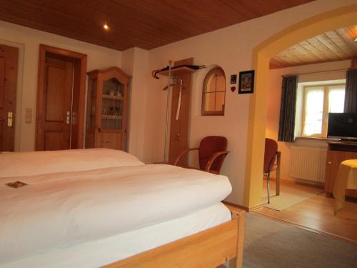 a bedroom with a bed and a tv in it at Gästehaus Unruh in Oberammergau