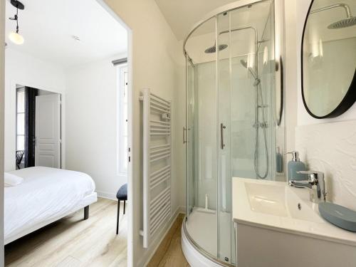 une salle de bain avec une douche en verre et un lavabo dans l'établissement Le Lumineux - Cœur de Ville, à Chartres