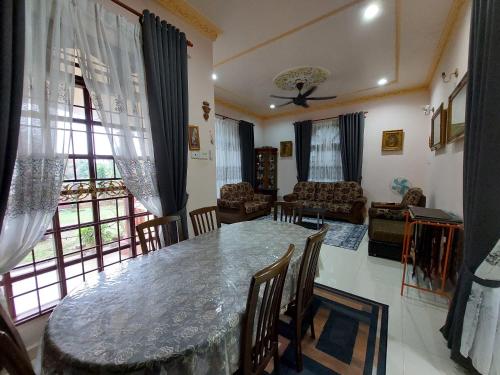 een woonkamer met een grote tafel en stoelen bij Rumah Teratak Bonda in Jertih
