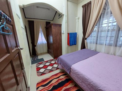 een kleine slaapkamer met een bed en een raam bij Rumah Teratak Bonda in Jertih