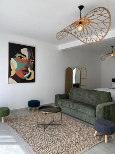 uma sala de estar com um sofá verde e uma mesa em Les Villas 400, Saint-Pierre em Saint-Pierre