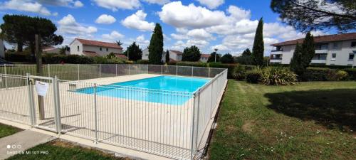 una valla alrededor de una piscina en un patio en T2 Cosy ₪ Residence Securise ₪ Airbus ₪ Piscine en Colomiers