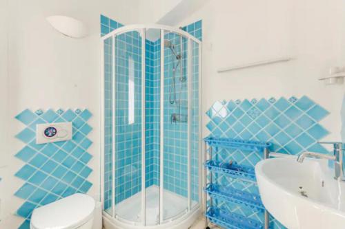 Baño de azulejos azules con aseo y lavamanos en Li Padulazzi Il Corbezzolo, en Li Valcaggi