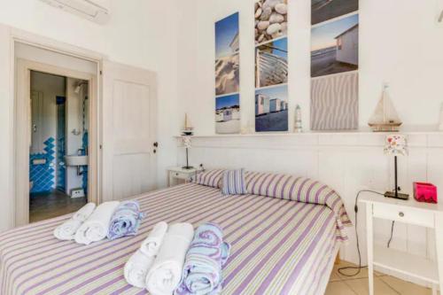 1 dormitorio con 1 cama con toallas en Li Padulazzi Il Corbezzolo, en Li Valcaggi