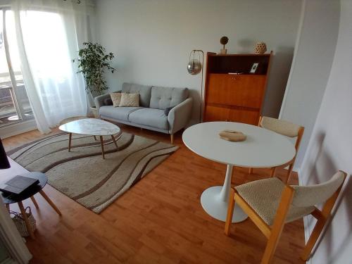un salon avec une table et un canapé dans l'établissement Appartement avec parking et balcon vue Cathédrale, à Chartres