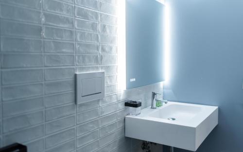 ein Badezimmer mit einem weißen Waschbecken und einem Spiegel in der Unterkunft Opera Boutique in Catania