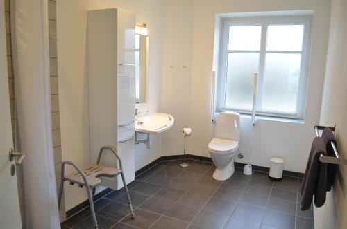 a bathroom with a toilet and a sink and a window at Naturperlen in Rødekro
