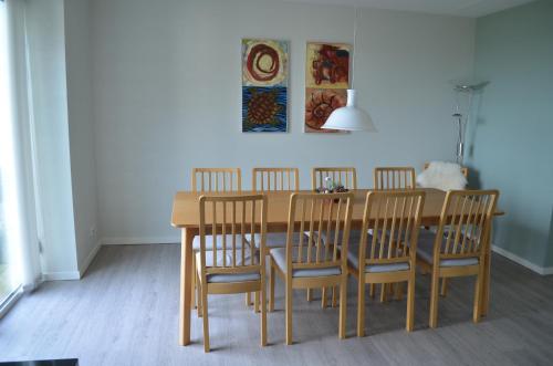 a dining room table with four chairs and a painting at Naturperlen in Rødekro
