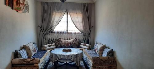 阿加迪爾的住宿－Residence salam，带沙发、桌子和窗户的客厅