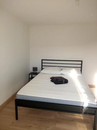 Una cama en un dormitorio con una bolsa. en Typique cabanon provençal rénové Attention escalier extérieur pour accéder au 1er étage, en Gonfaron