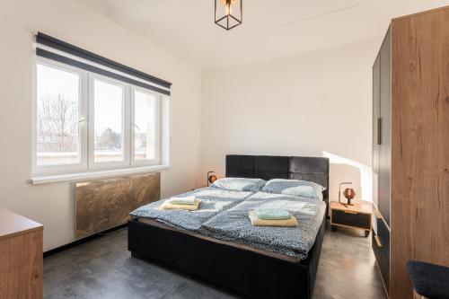 a bedroom with a large bed with two towels on it at Apartmány Praha-Modřany in Prague