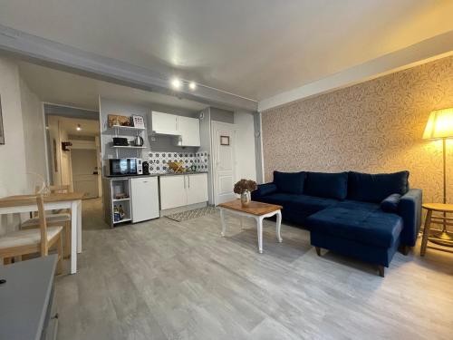 un salon avec un canapé bleu et une table dans l'établissement The Heart of Chartres, à Chartres