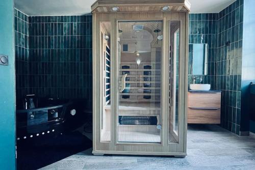 y baño con cabina de cristal con ducha. en Love Room L' Orientale / Jacuzzi / Sauna, en Château-Landon