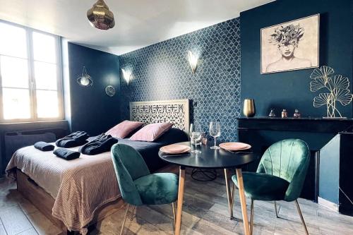 a bedroom with a bed and a table and chairs at Love Room L' Orientale / Jacuzzi / Sauna in Château-Landon