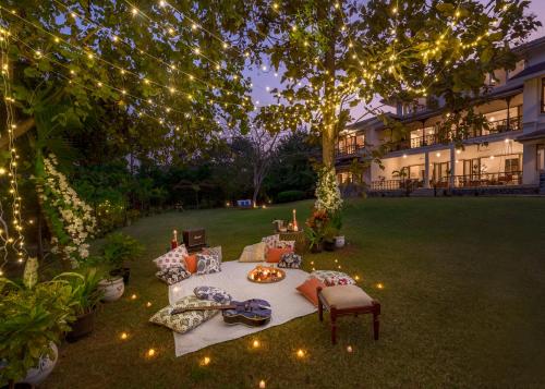 a picnic table in a yard with lights at SaffronStays Mograa L'Affaire - 5BR pet-friendly villa with private pool, gazebo & lawns near Kankeshwar Temple in Alibaug