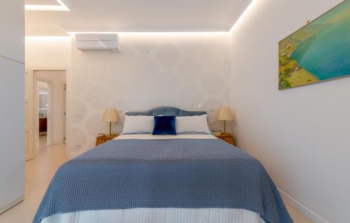 een slaapkamer met een bed met een blauwe en witte sprei bij Rosamarina in Sorrento