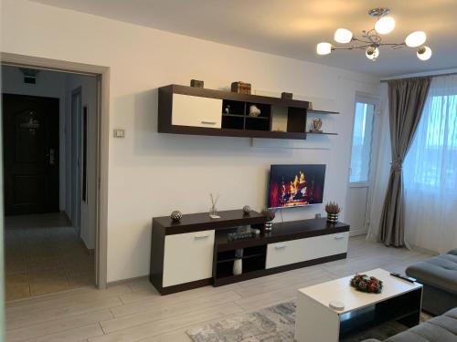 a living room with a tv on a wall at Victoriei Boulevard Private Apartment in Braşov