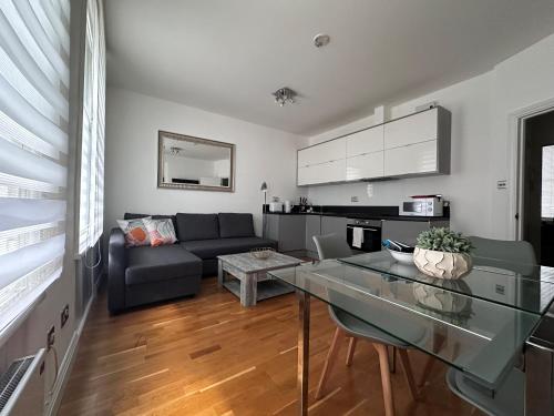 ein Wohnzimmer mit einem Sofa und einem Glastisch in der Unterkunft Apt 1, Soho Apartments 1st floor by Indigo Flats in London