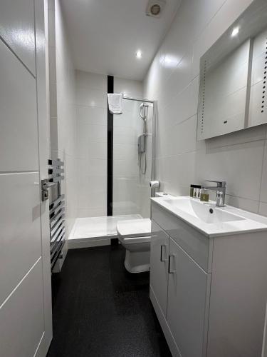 a white bathroom with a toilet and a sink at Apt 1, Soho Apartments 1st floor by Indigo Flats in London