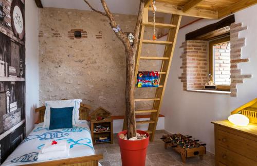 a room with a bed and a tree in it at Maison de la Combe in Castelmoron-sur-Lot
