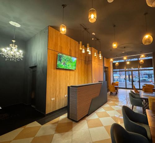 a dining room with a tv on a wall at Hotel Fama in Skopje