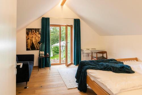 een slaapkamer met een bed en een groot raam bij Ferienhaus am Park in Grafenau