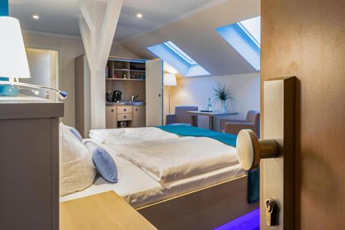 a bedroom with a bed and a room with a kitchen at Hotel Leuchtfeuer in Freest