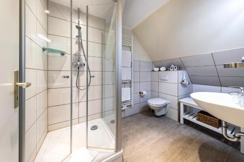 a bathroom with a shower and a sink and a toilet at Hotel Leuchtfeuer in Freest