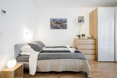 a bedroom with a bed and a dresser at Marina apartment at Danube - FREE PRIVATE PARKING! in Budapest