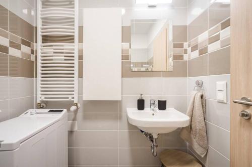 een witte badkamer met een wastafel en een spiegel bij Marina apartment at Danube - FREE PRIVATE PARKING! in Boedapest