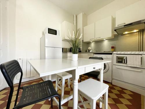 une cuisine blanche avec une table et des chaises blanches dans l'établissement Au fil de l’Eure, quartier authentique et plein de charme, à Chartres