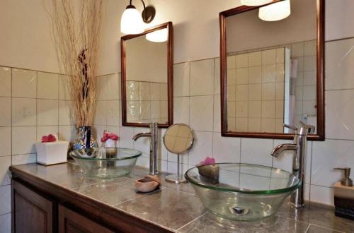 a bathroom with two sinks and two mirrors at Amazing 9 BR Villa in Cap Estate in Cap Estate