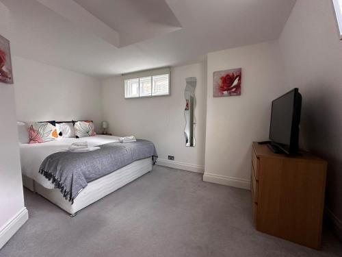 a bedroom with a bed and a flat screen tv at Apt 3, Soho Apartments 2nd & 3rd floors by Indigo Flats in London
