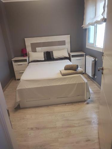 a bedroom with a bed with white sheets and pillows at Habitaciones en Ronda in Castro-Urdiales