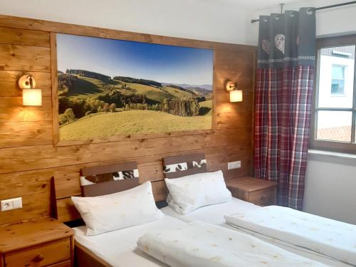 two beds in a room with a picture on the wall at Schlosshof - der Urlaubsbauernhof in Elzach