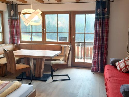ein Wohnzimmer mit einem Tisch und einem Fenster in der Unterkunft Schlosshof - der Urlaubsbauernhof in Elzach