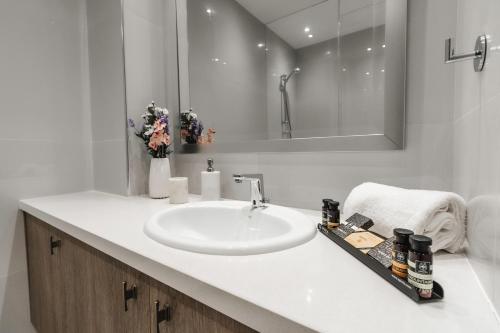 a white bathroom with a sink and a mirror at 16 EXECUTIVE SUITES in Nicosia