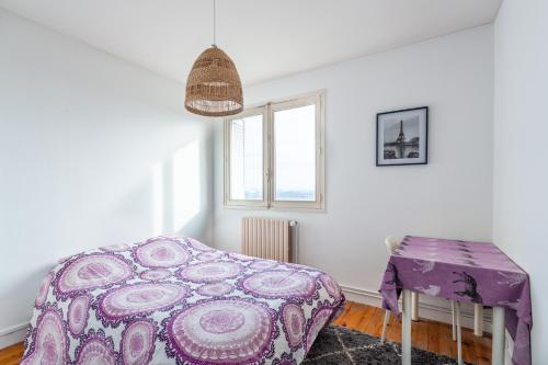 1 dormitorio con cama morada y mesa en Appart lumineux à emplacement idéal refait à neuf, en Oullins