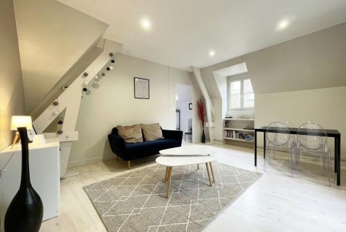 ein Wohnzimmer mit einem Sofa und einem Tisch in der Unterkunft Le Spacieux in Chartres