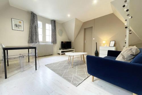 a living room with a blue couch and a table at Le Spacieux in Chartres