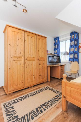 a living room with wooden cabinets and a kitchen at Ferienhaeuser Deichkrone in Bensersiel